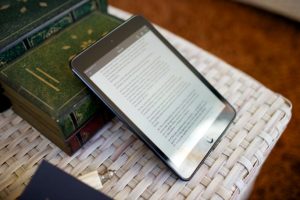 Tabletti pöydällä jossa on kirkon aineistoa